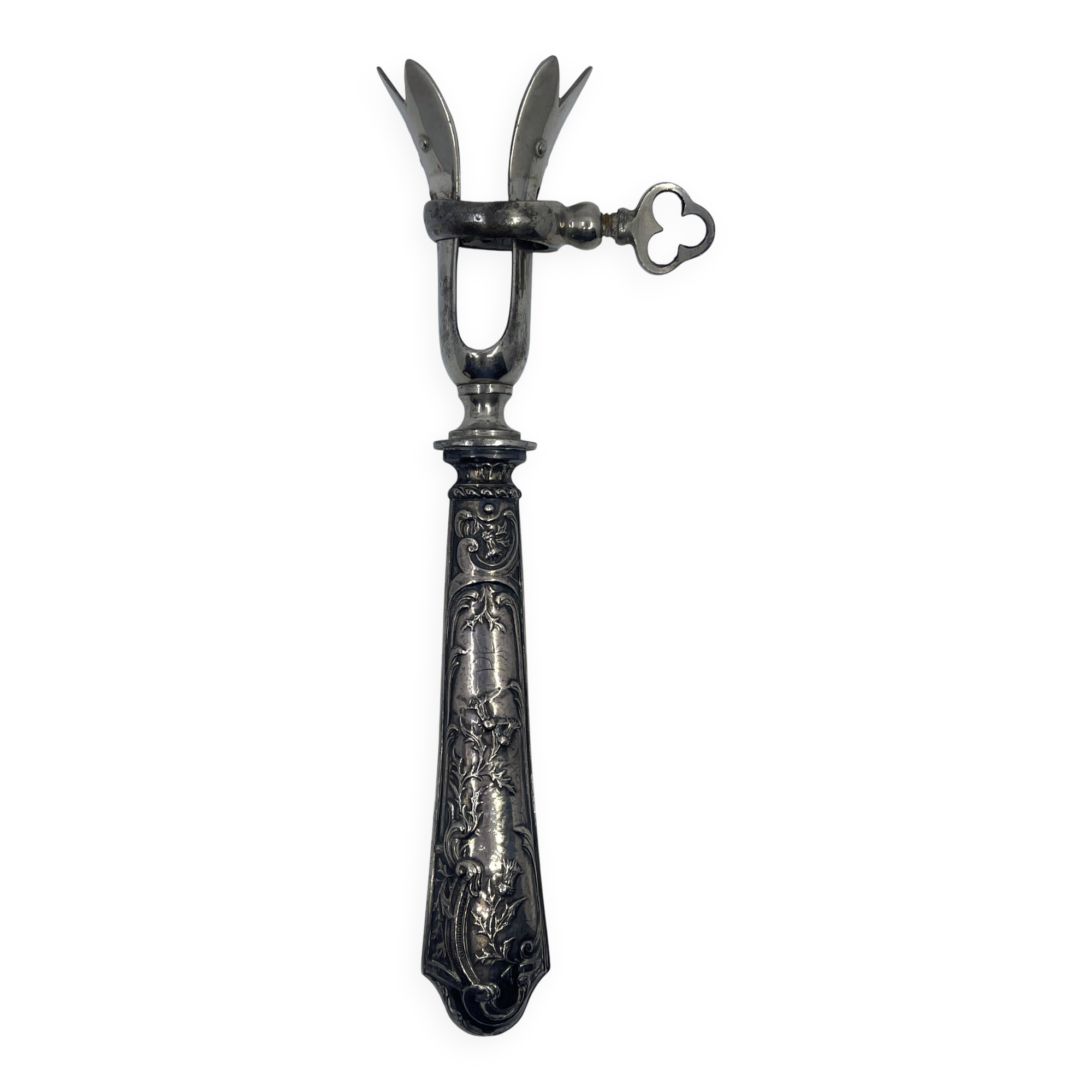 Silver-plated metal leg of lamb handle with engraved thistle flower patterns.