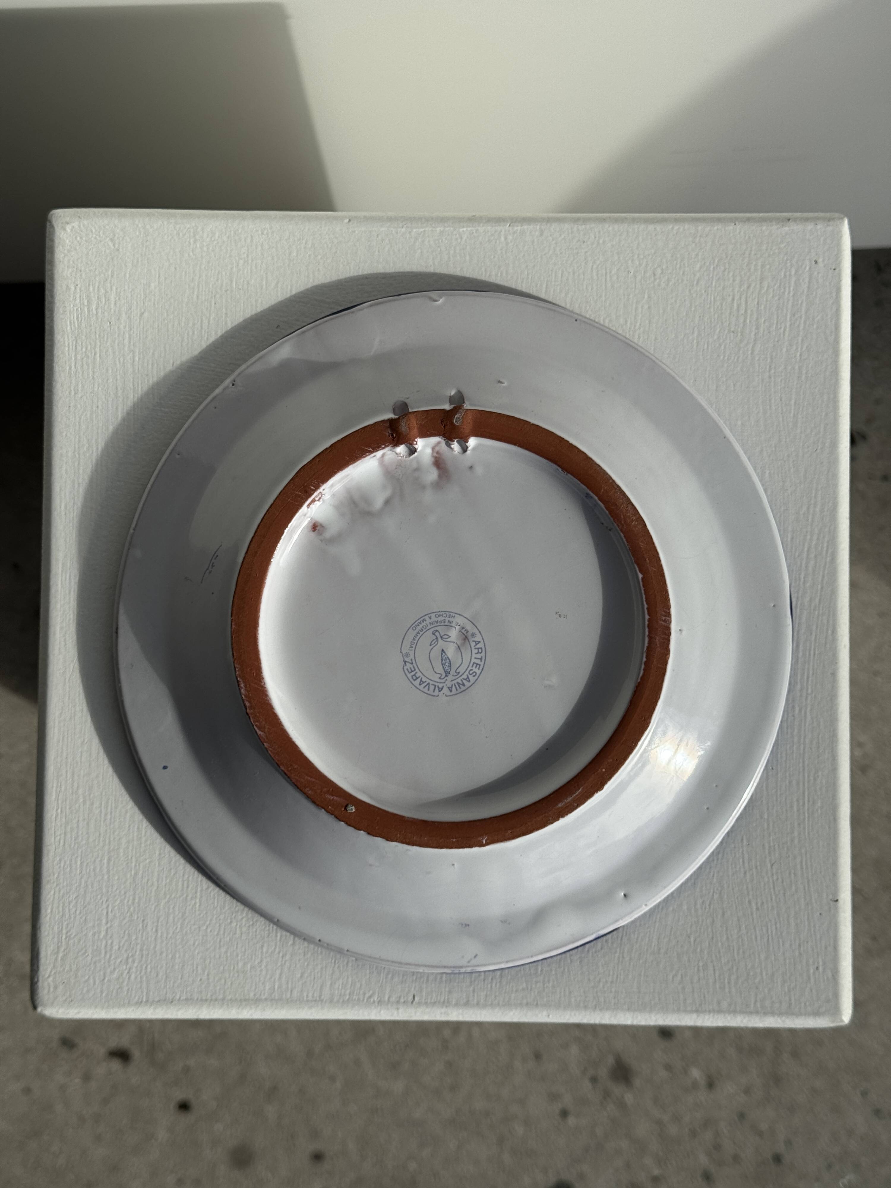 Artesania Alvarez Spanish plate in terracotta with blue plant motif.