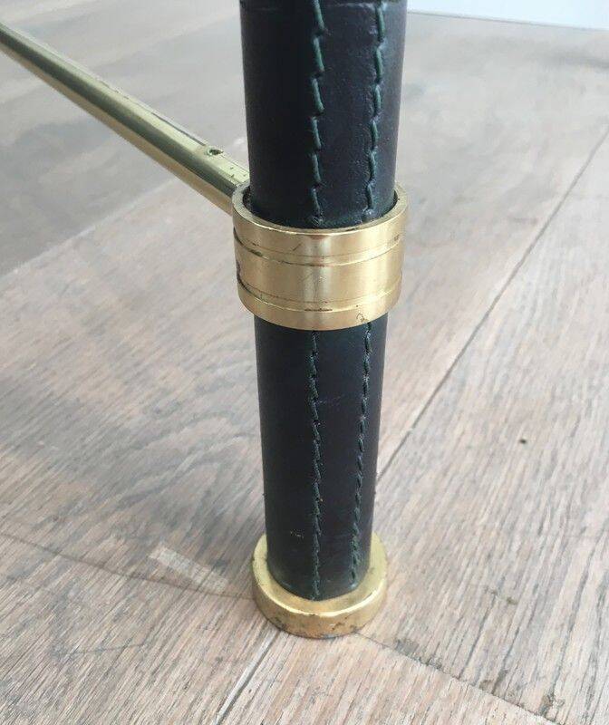 Brass coffee table upholstered in black leather. In the style of Jacques Adnet.