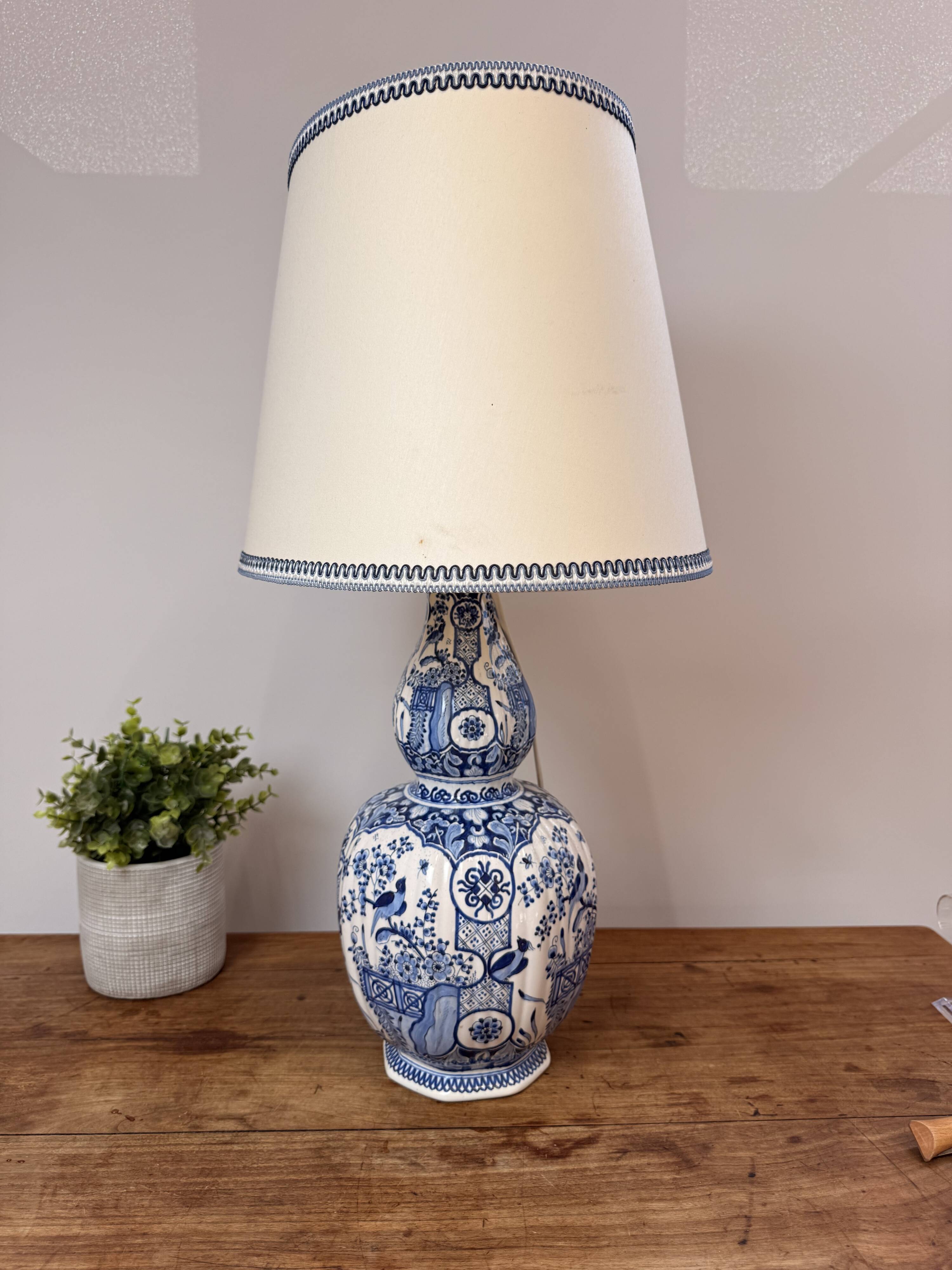 Blue and white Delft ceramic table lamp decorated with birds and flowers.
