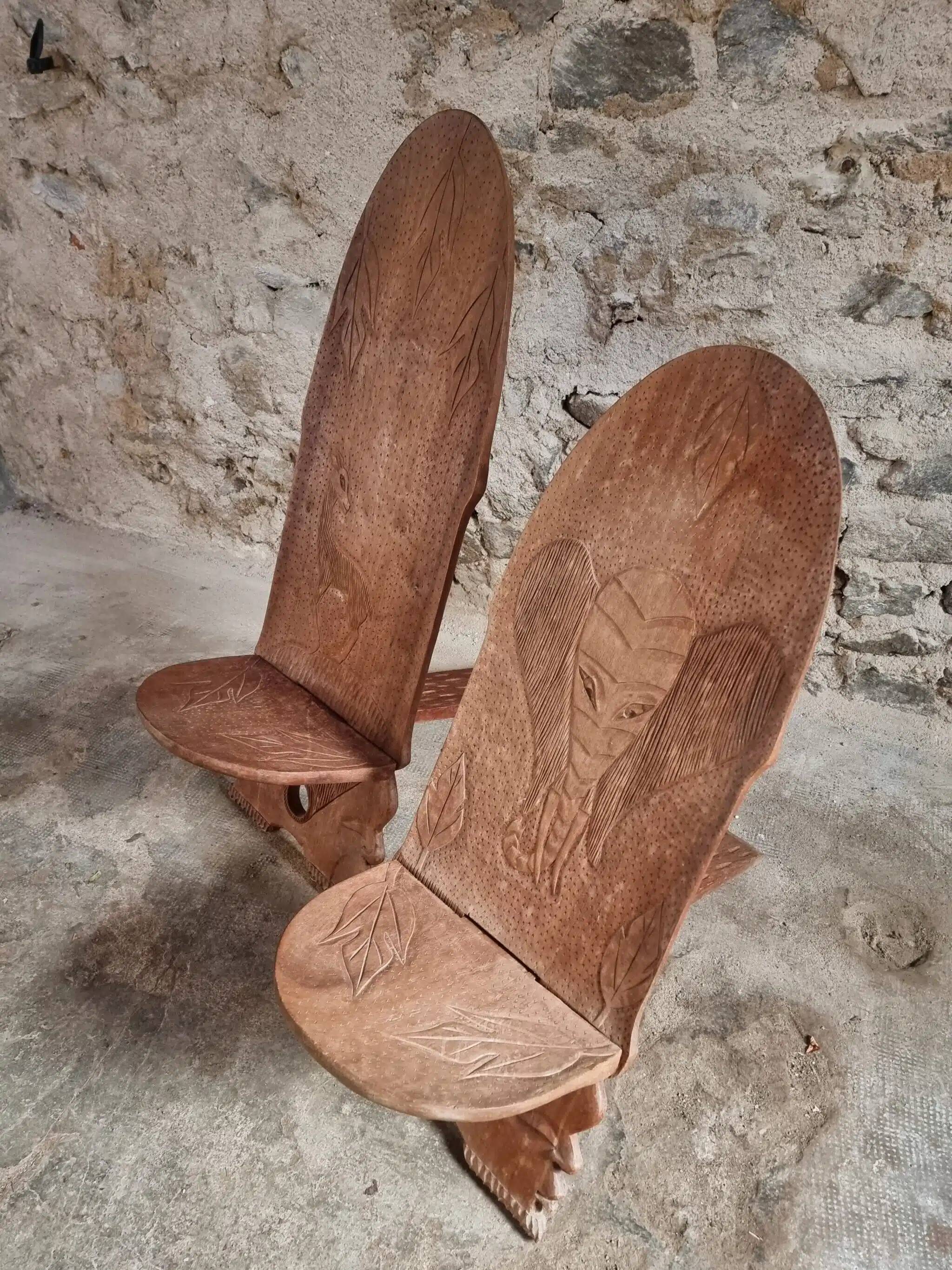 Pair of hand-carved wooden folding chairs – African origin, animal and face motifs, mid-20th century