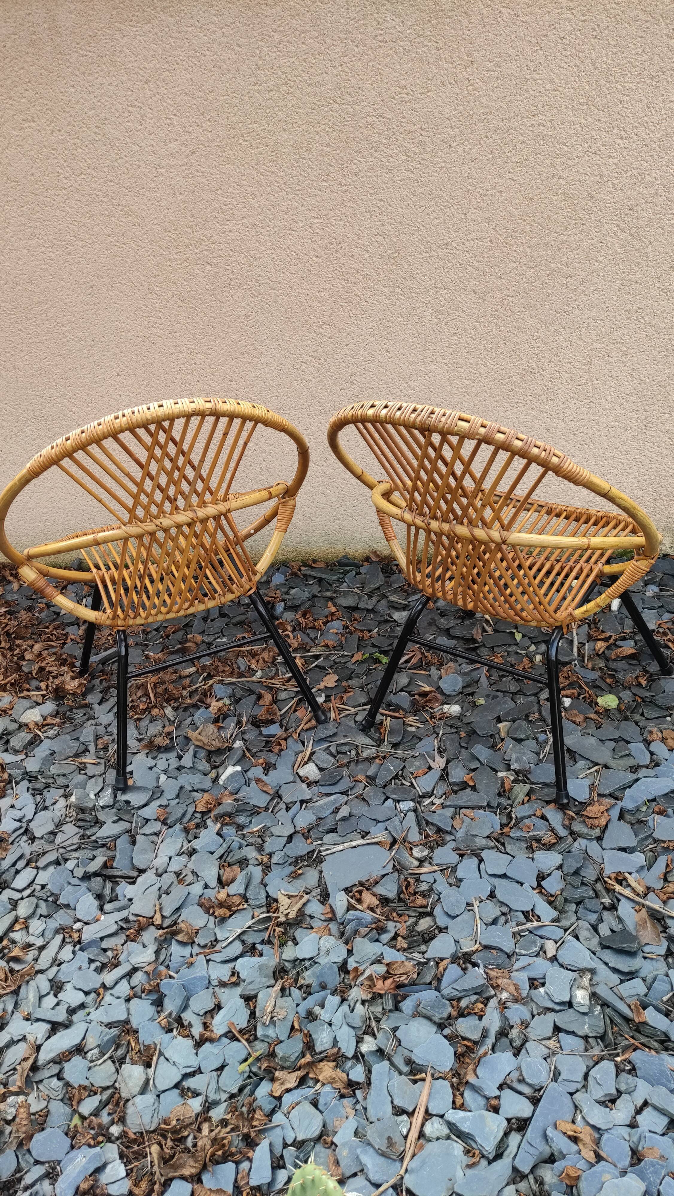 Paire de fauteuils coquilles ou corbeille en rotin tressé, pieds en métal