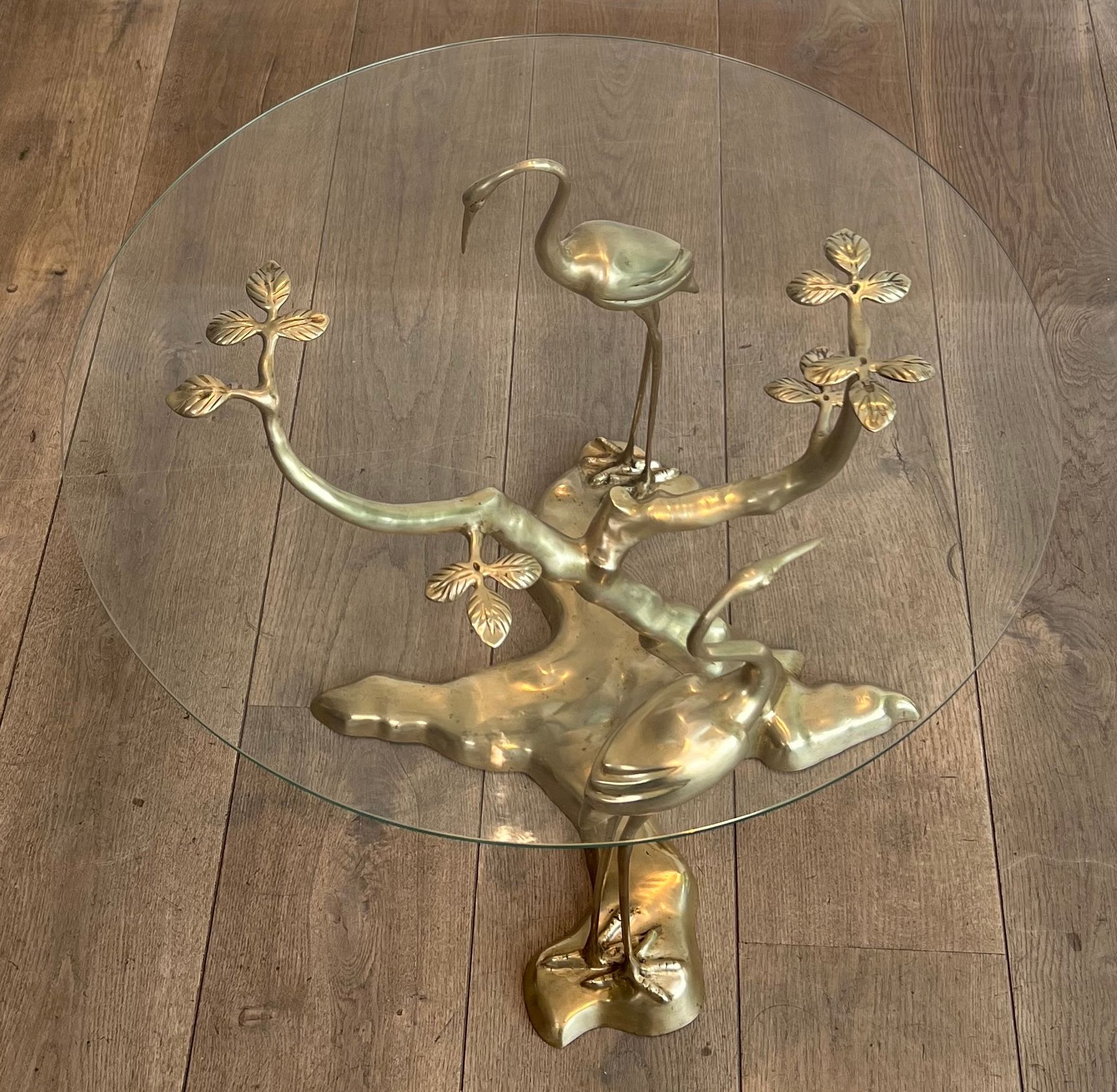 Coffee table model with cranes surrounding a brass bonsai and round glass top by Willy Daro.