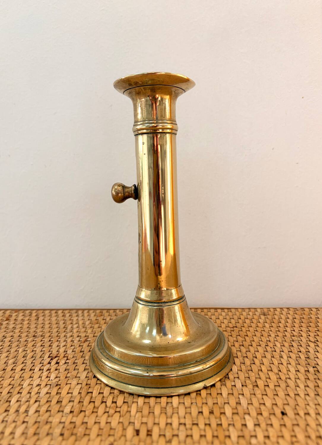 Old brass candlestick with push button.
