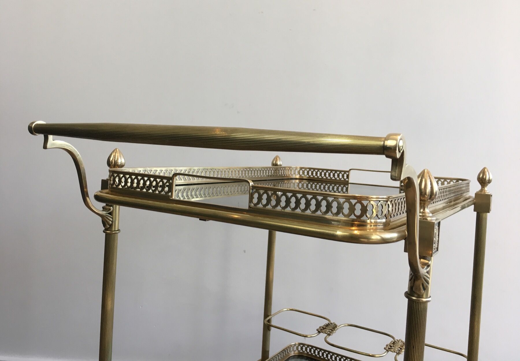 Neoclassical style rolling table in brass with blue glass tops