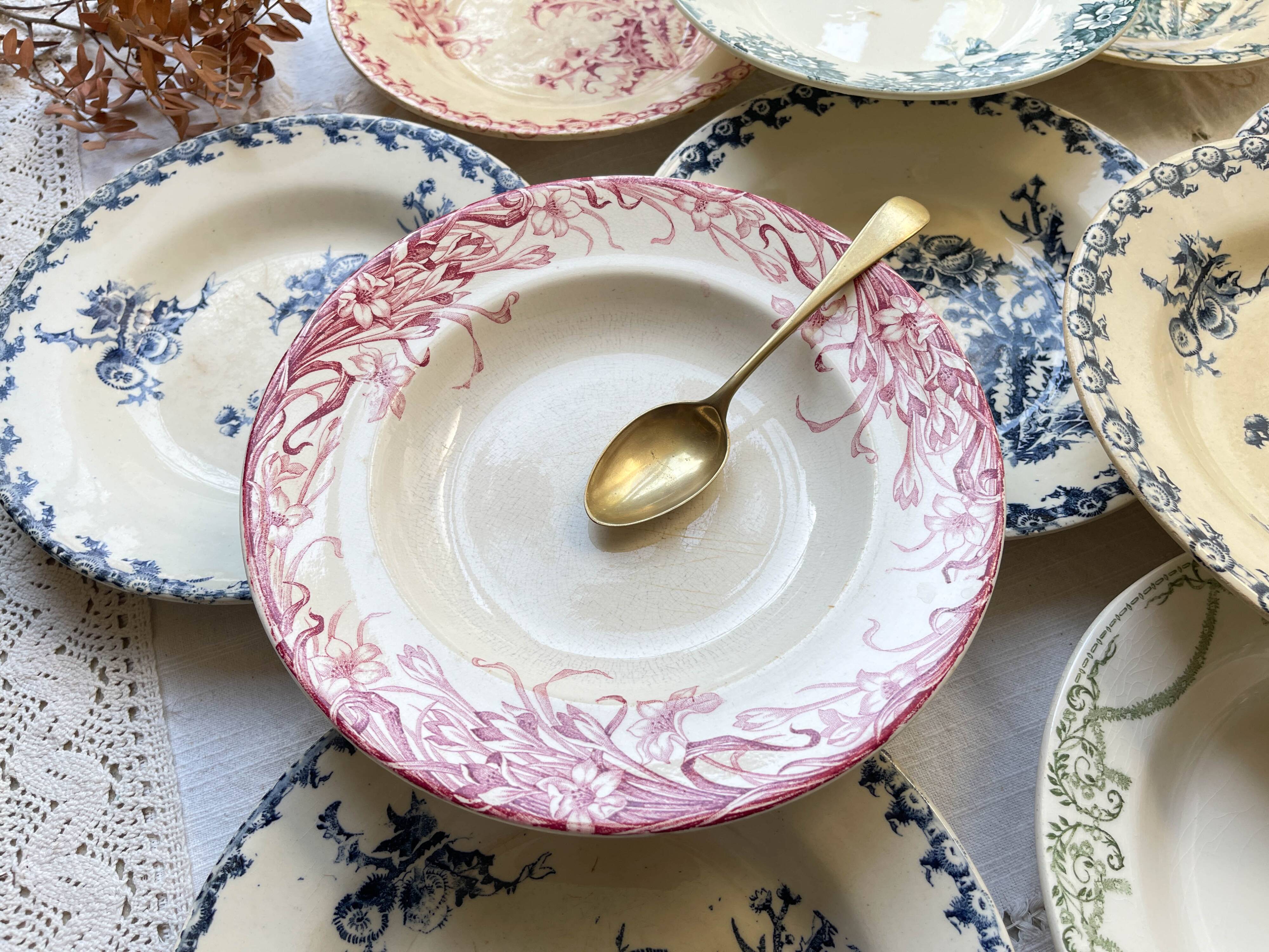 10 mismatched vintage soup plates in blue, green, and red ironstone