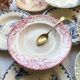 10 mismatched vintage soup plates in blue, green, and red ironstone