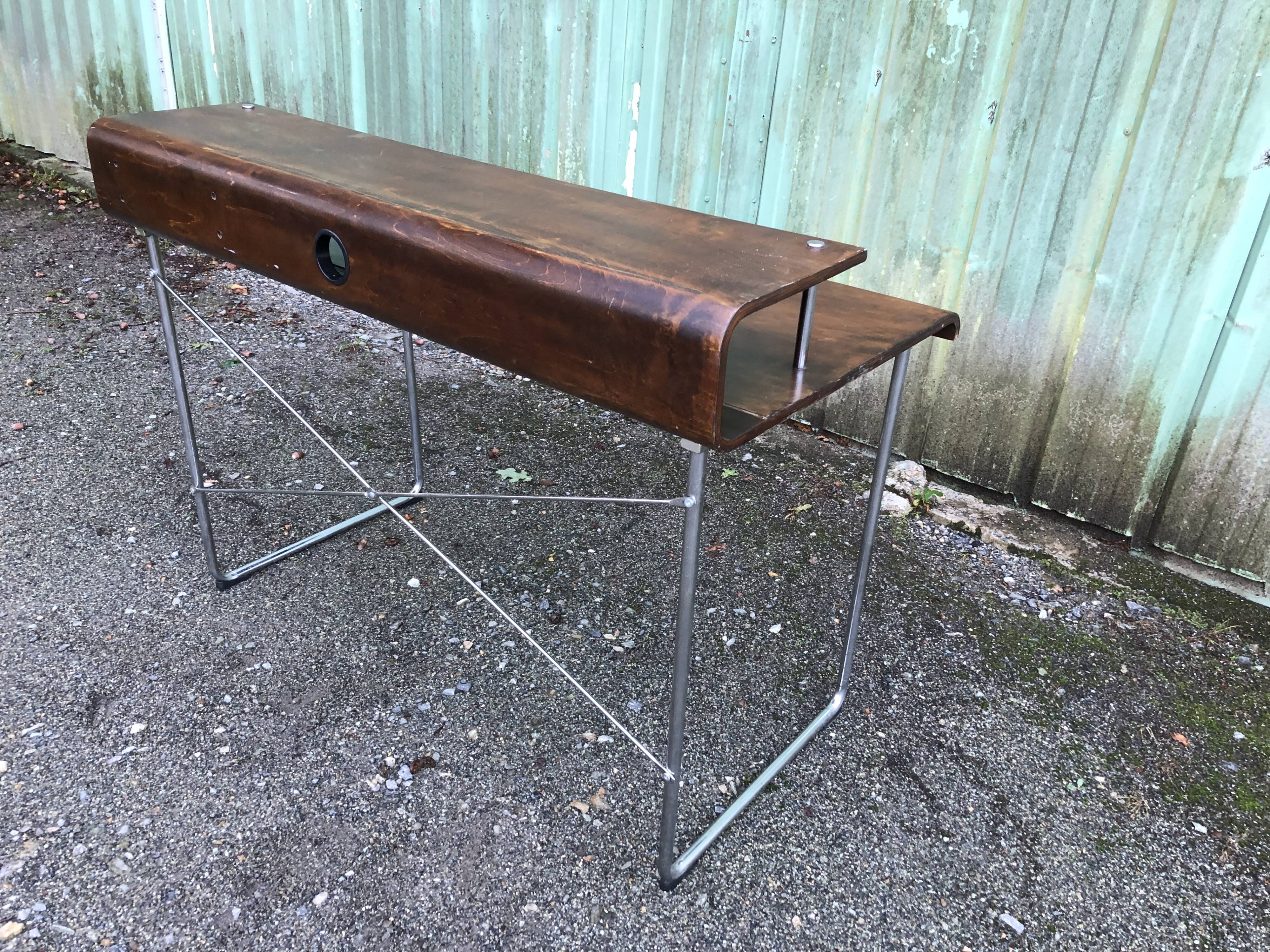 Design desk in formed glued laminated wood with chrome tubular base.