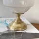 Antique white opaline glass globe table lamp with a brass base.