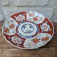 Antique Imari deep plate with red and blue floral decoration, 21.5cm.