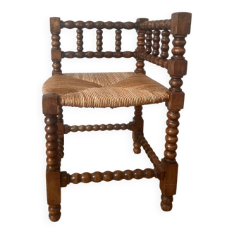 Chair by the fireplace made of wood and straw.