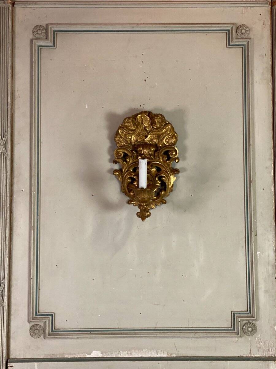 Paire d’appliques en bois sculpté et doré surmontées de deux têtes d’angelots, Italie
