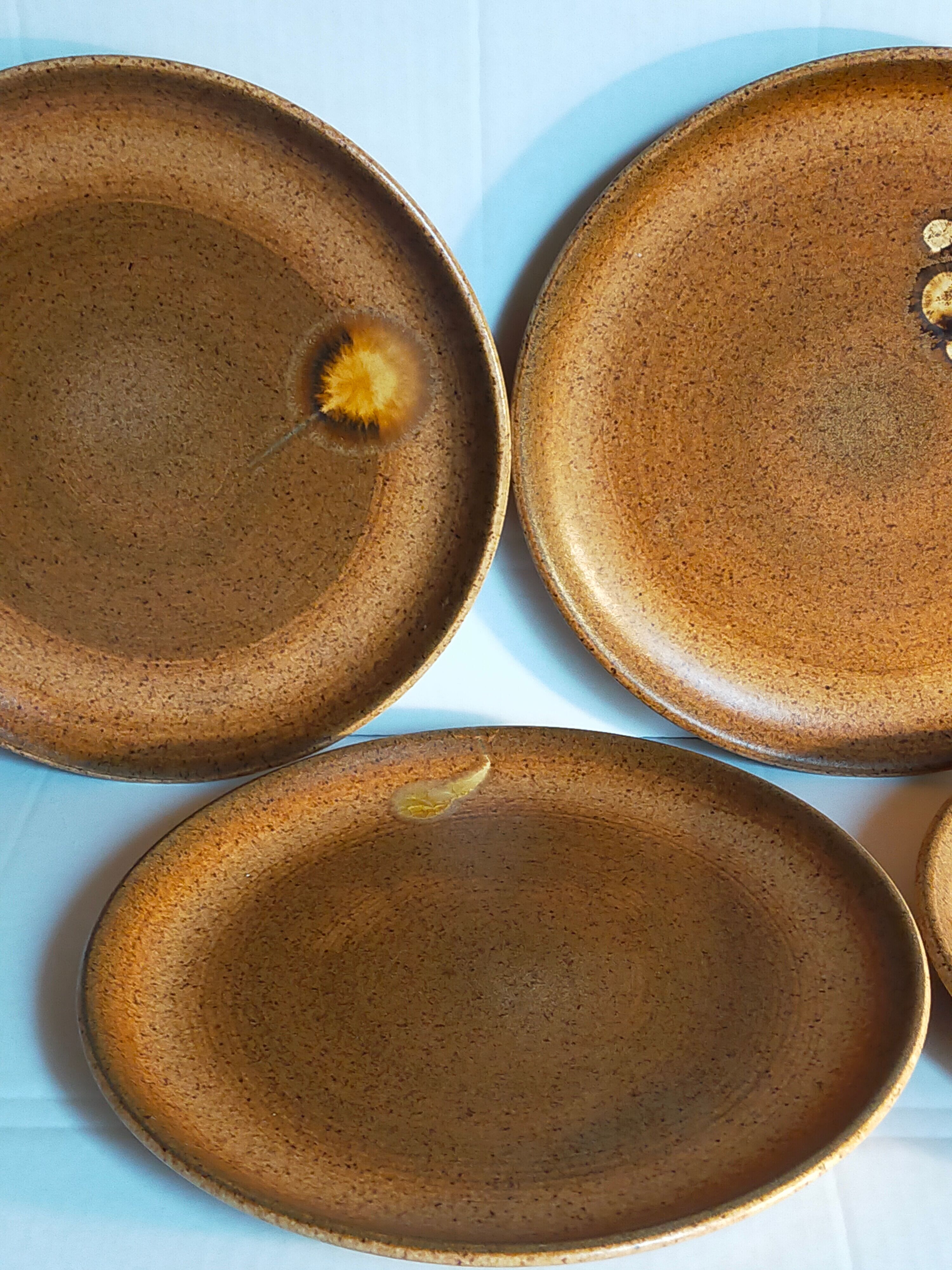Four vintage glazed stoneware potter's plates