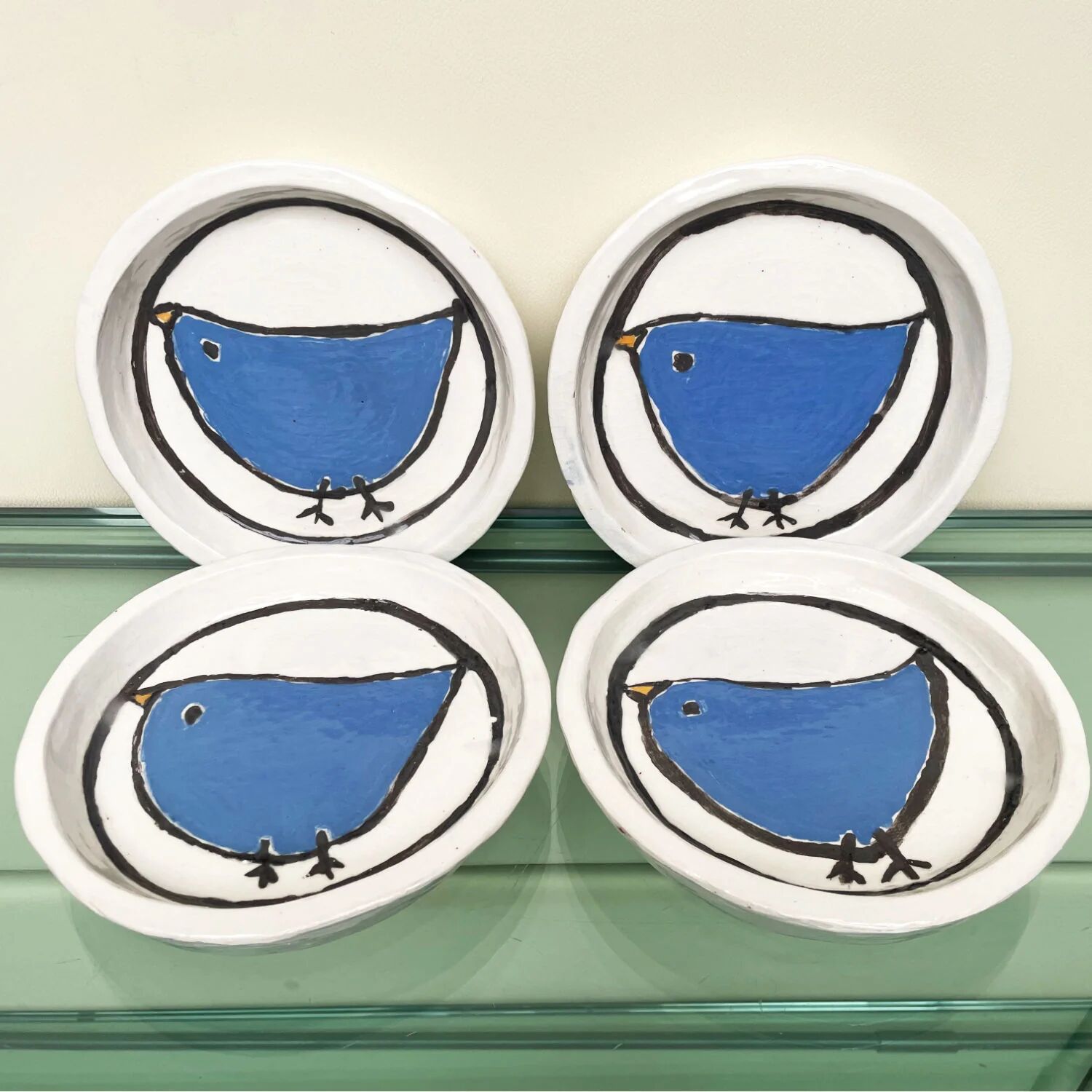 Handmade white ceramic plates with a blue bird in folk art style, set of 4.