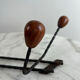 Wall-mounted coat rack in wrought iron with turned wooden knobs.