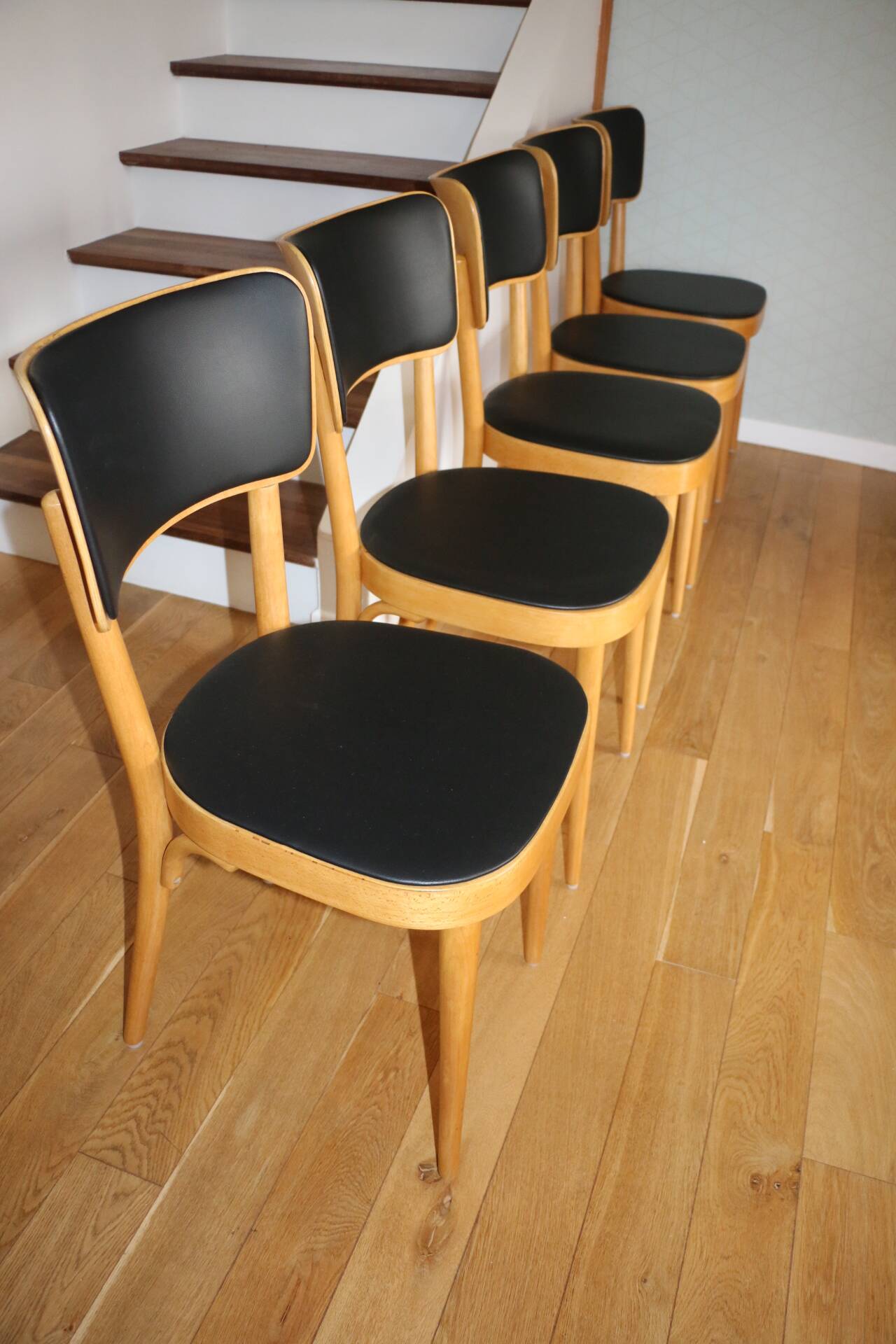 5 baumann chairs with large backs in black faux leather.