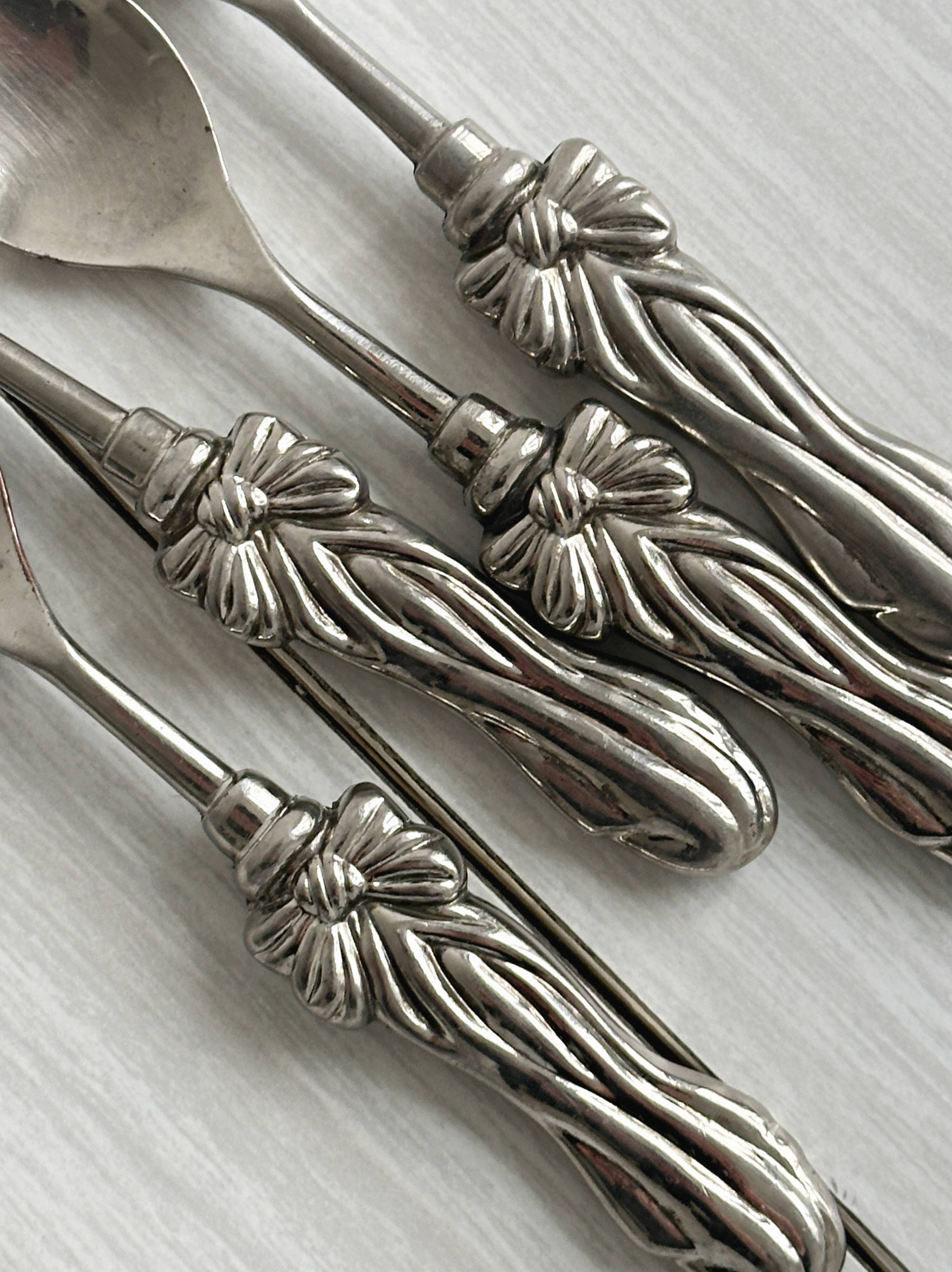 Antique small spoons with a metal bow design