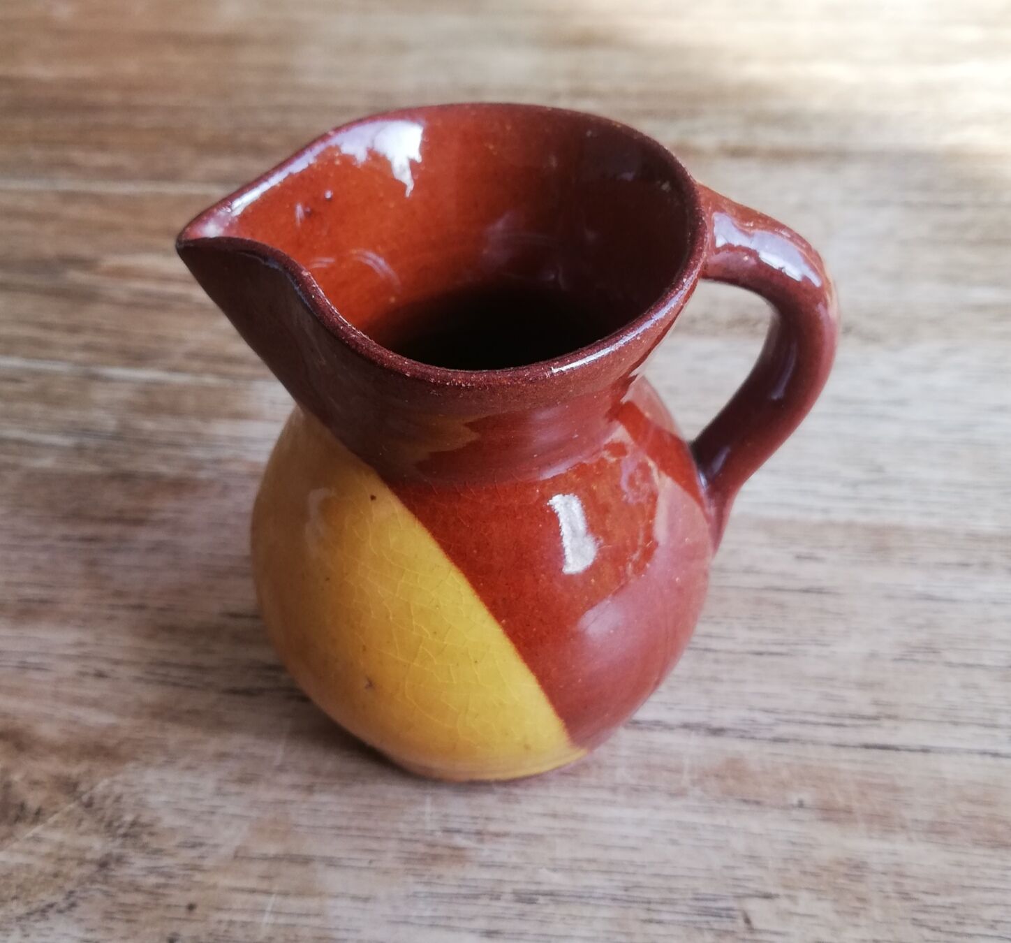 Small two-tone brown-yellow terracotta pitcher