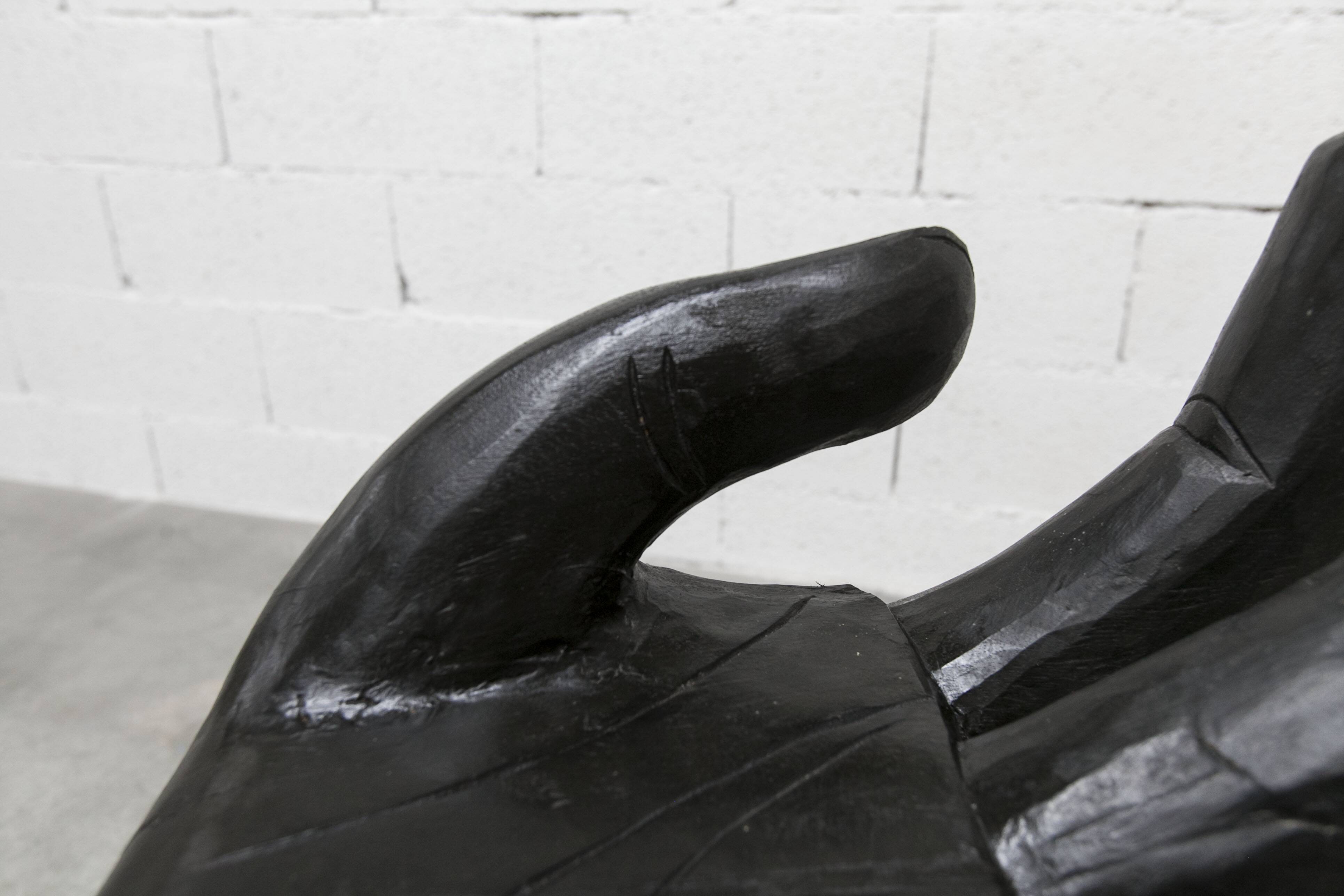 Black armchair chair in carved wood in the shape of a hand