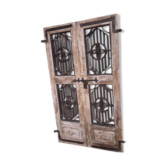 Old chiseled teak door with openwork wrought iron panels