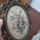 Golden brass frame with bouquet of flowers on silky fabric