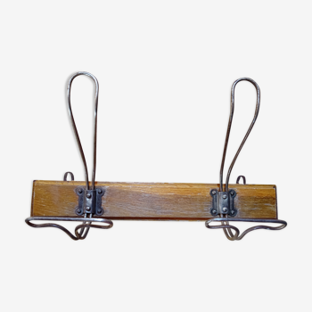 Wall coat rack with two metal hooks.