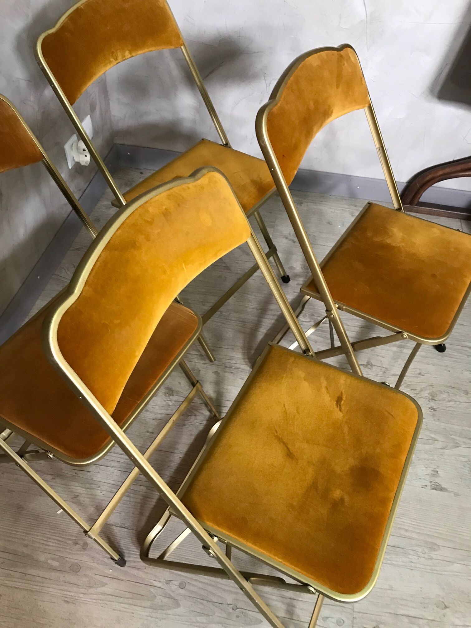 Four folding velvet and brass chairs