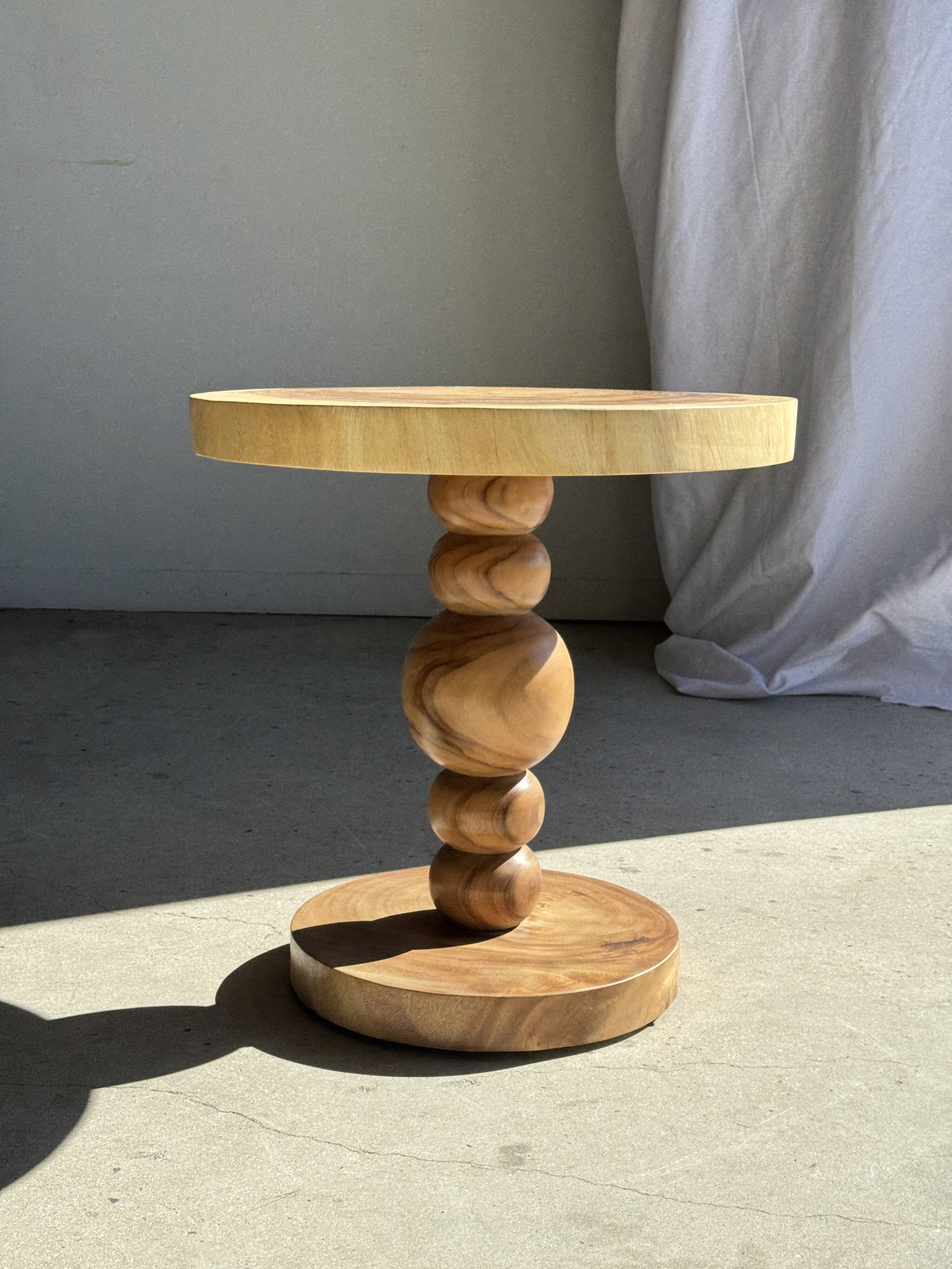 Coffee table in solid suar with central leg and spheres H56.5 D55.5