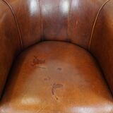 Sheep leather club chair in a cognac color and finished with piping