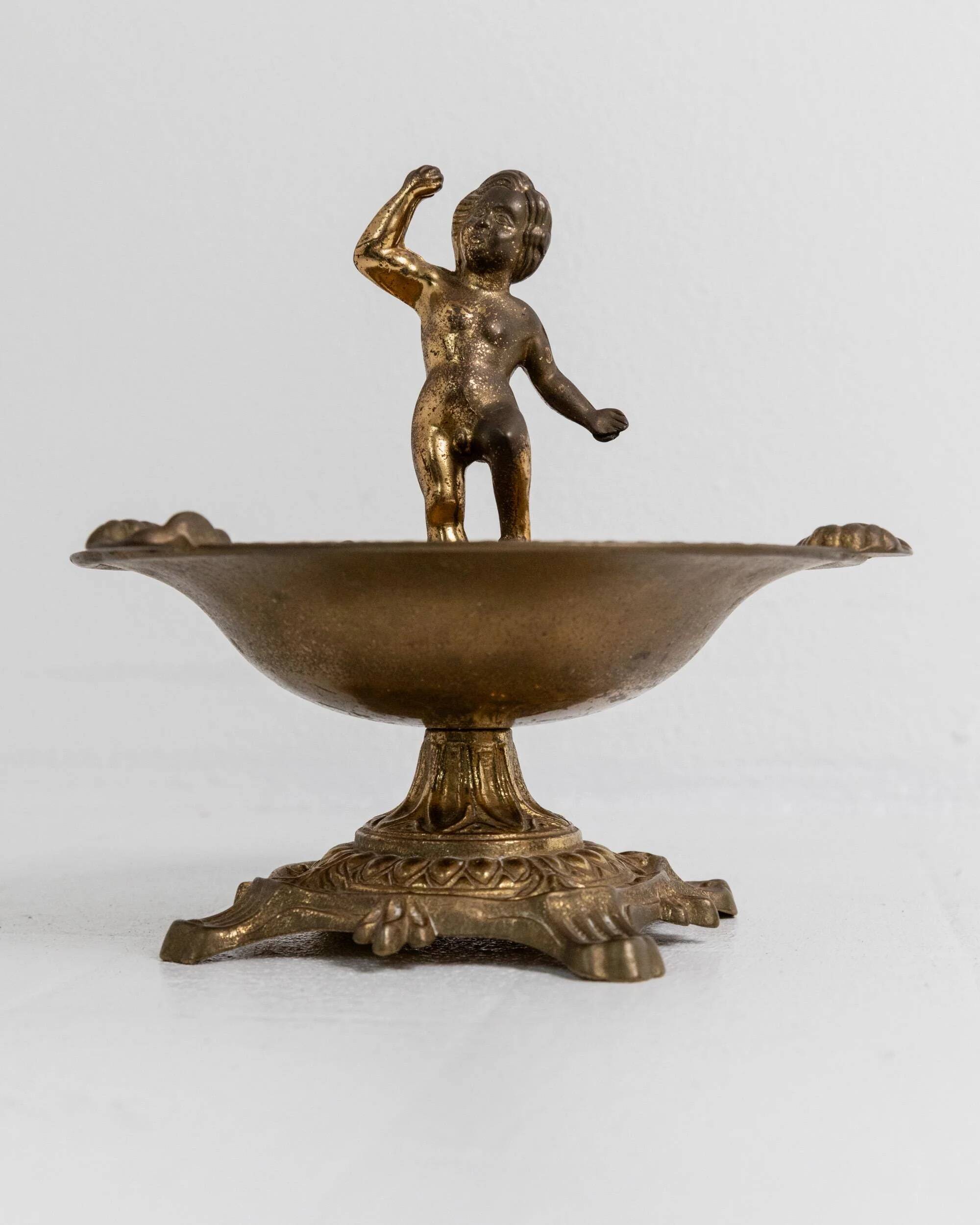 Vintage brass ashtray from the 1940s with a nude boy figurine on a footed base.