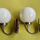 Pair of chrome metal wall lights with white glass globe.