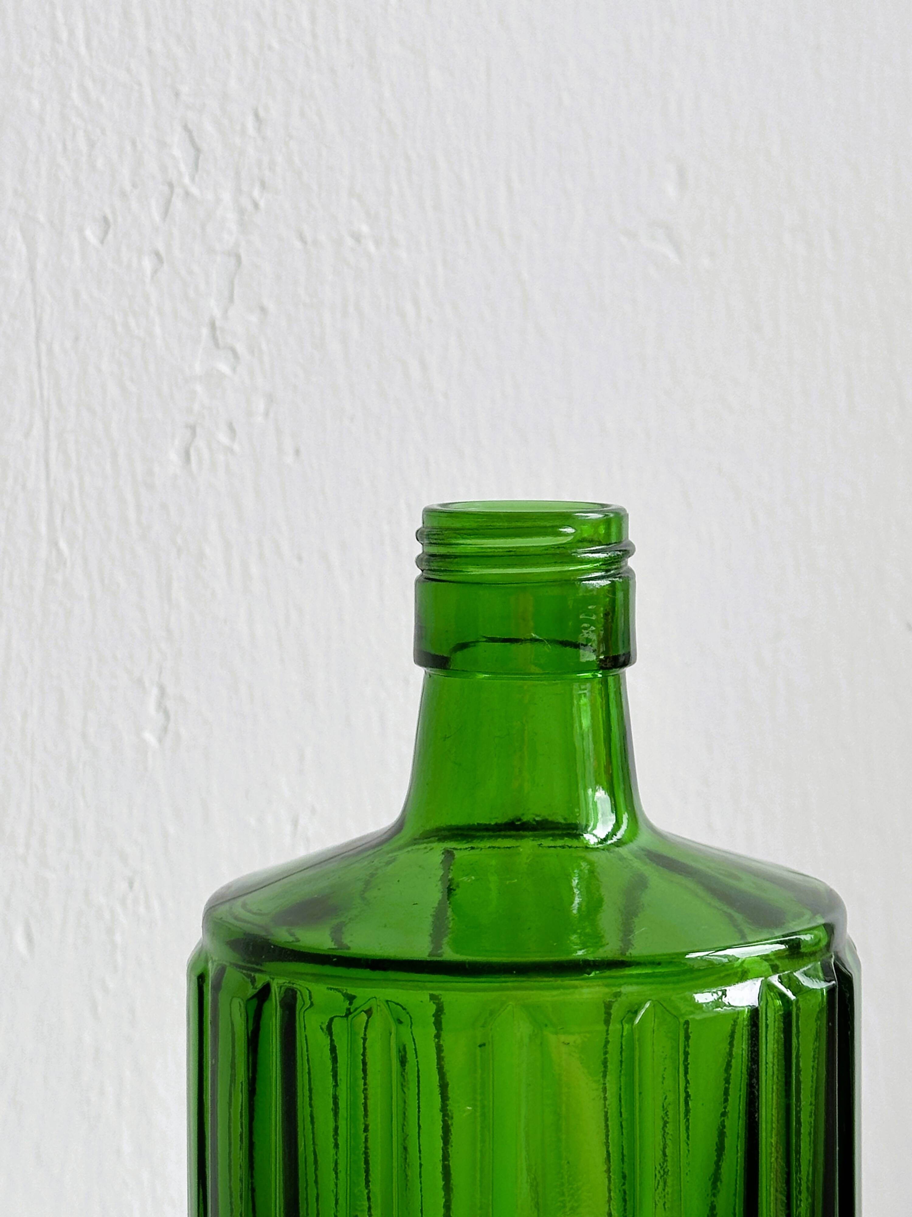 Green glass bottle, ribbed design.