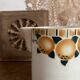 Old ceramic pitcher with orange decoration.