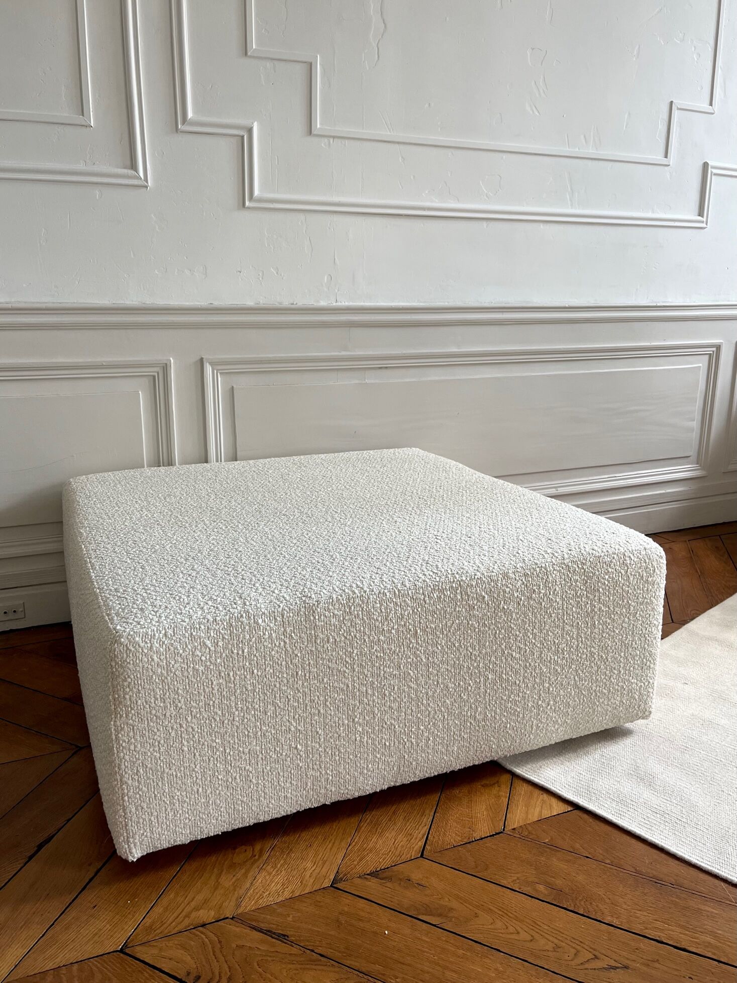 Square ottoman and its cushions in buckle fabric