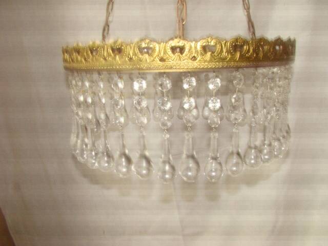 circular chandelier with a brass frame and crystal drops