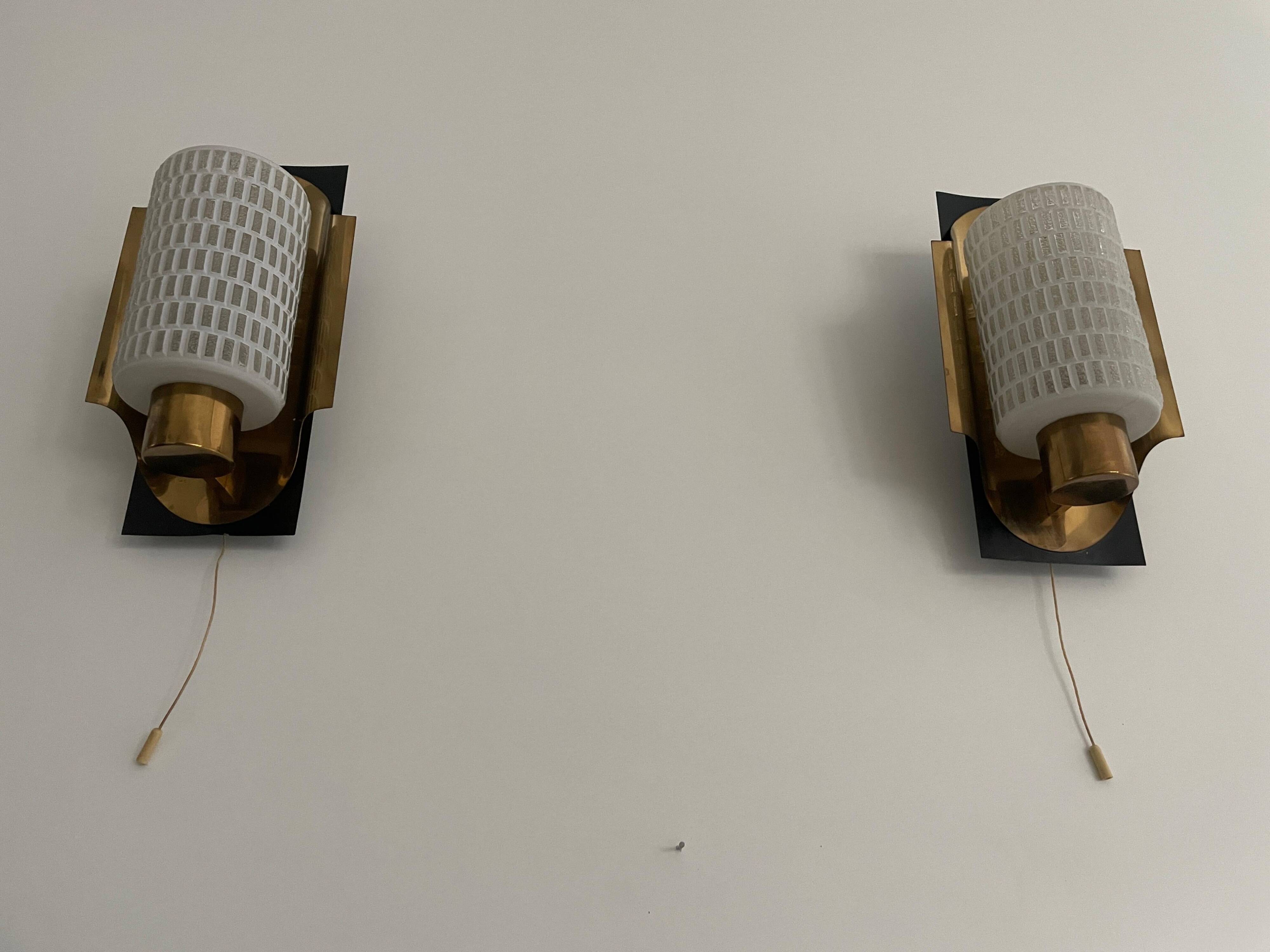 Mid-century pair of wall sconces in textured glass and brass, 1950s, Germany.