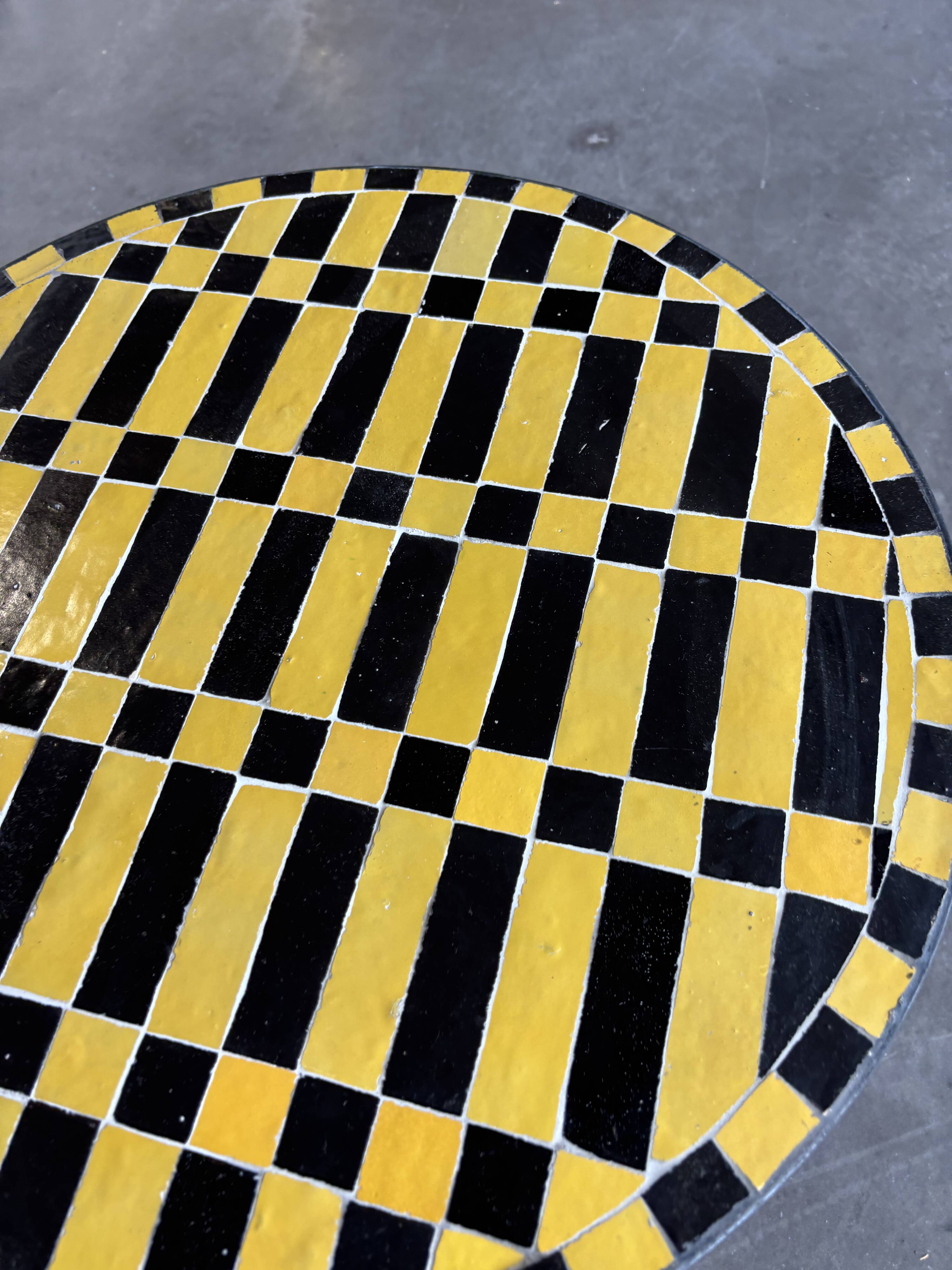 Round coffee table in yellow and black zellige, Moroccan graphic pattern.