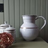 Old enamelled metal jug with gold trim.