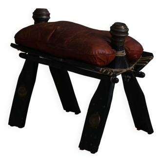 Dark red upholstered camel saddle stool, 20th century, North Africa.