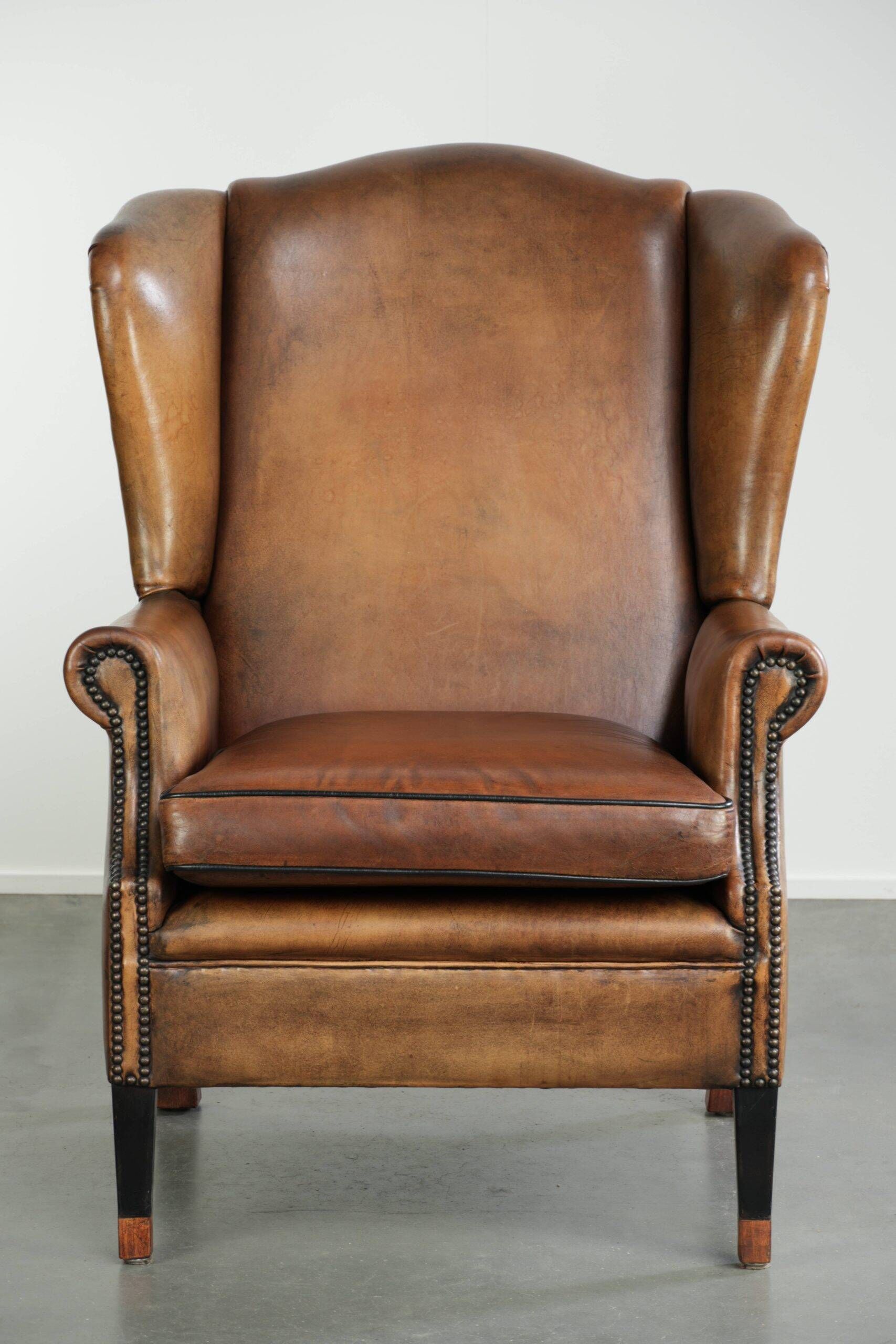 Sheepskin wingback armchair with patina finished with decorative nails