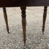 Table ronde en noyer de 130 cm de diamètre .