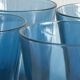 Four small translucent blue glasses.