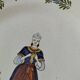 Hand-painted Breton plate, decorated with a woman knitting, 1950s
