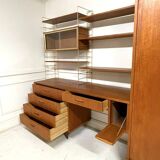 A piece of furniture combining a desk, wardrobe, and shelves.