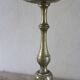 Brass candle holder with flowers and round shape.