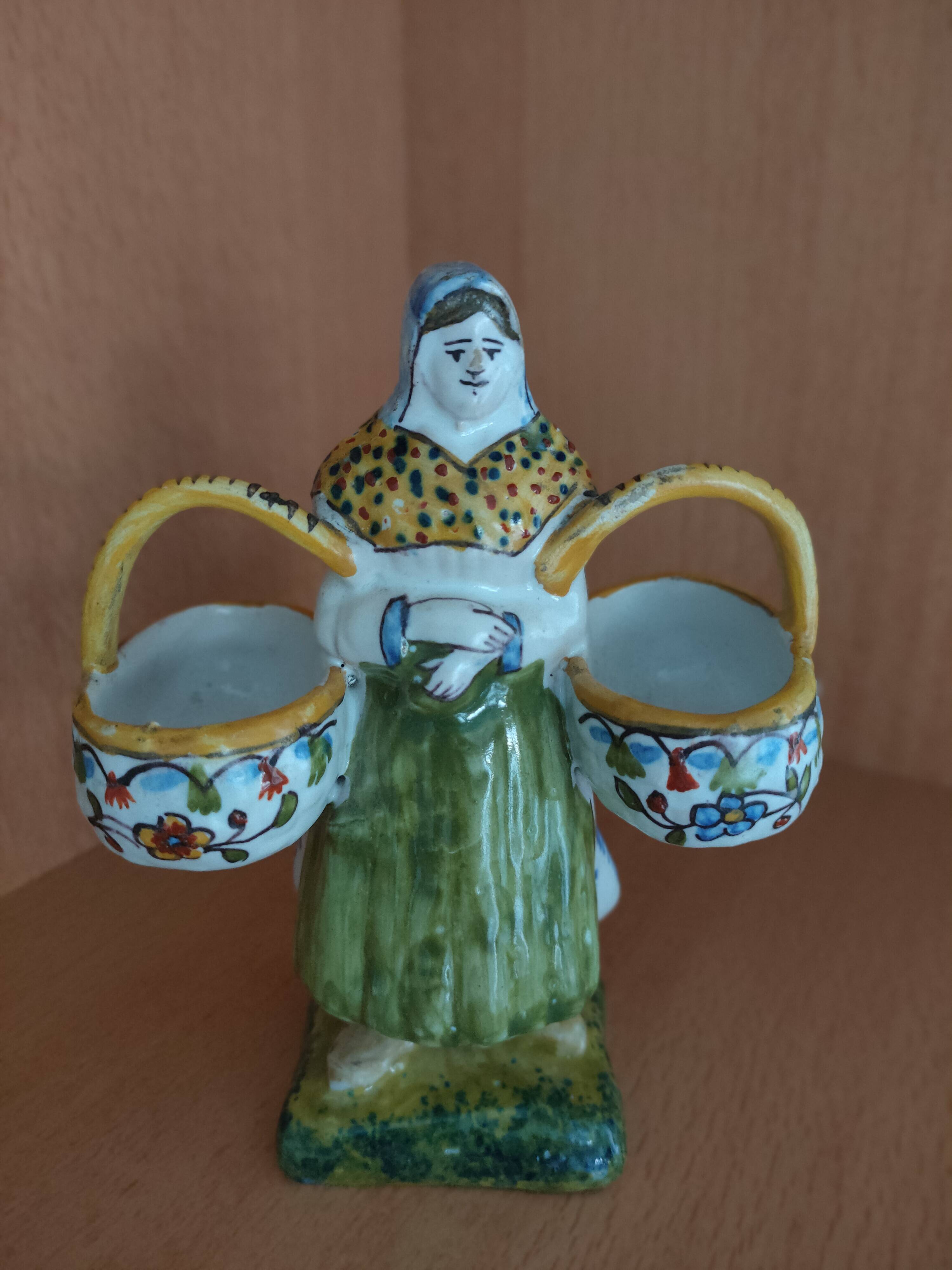 Antique earthenware salt cellar with a woman with baskets
