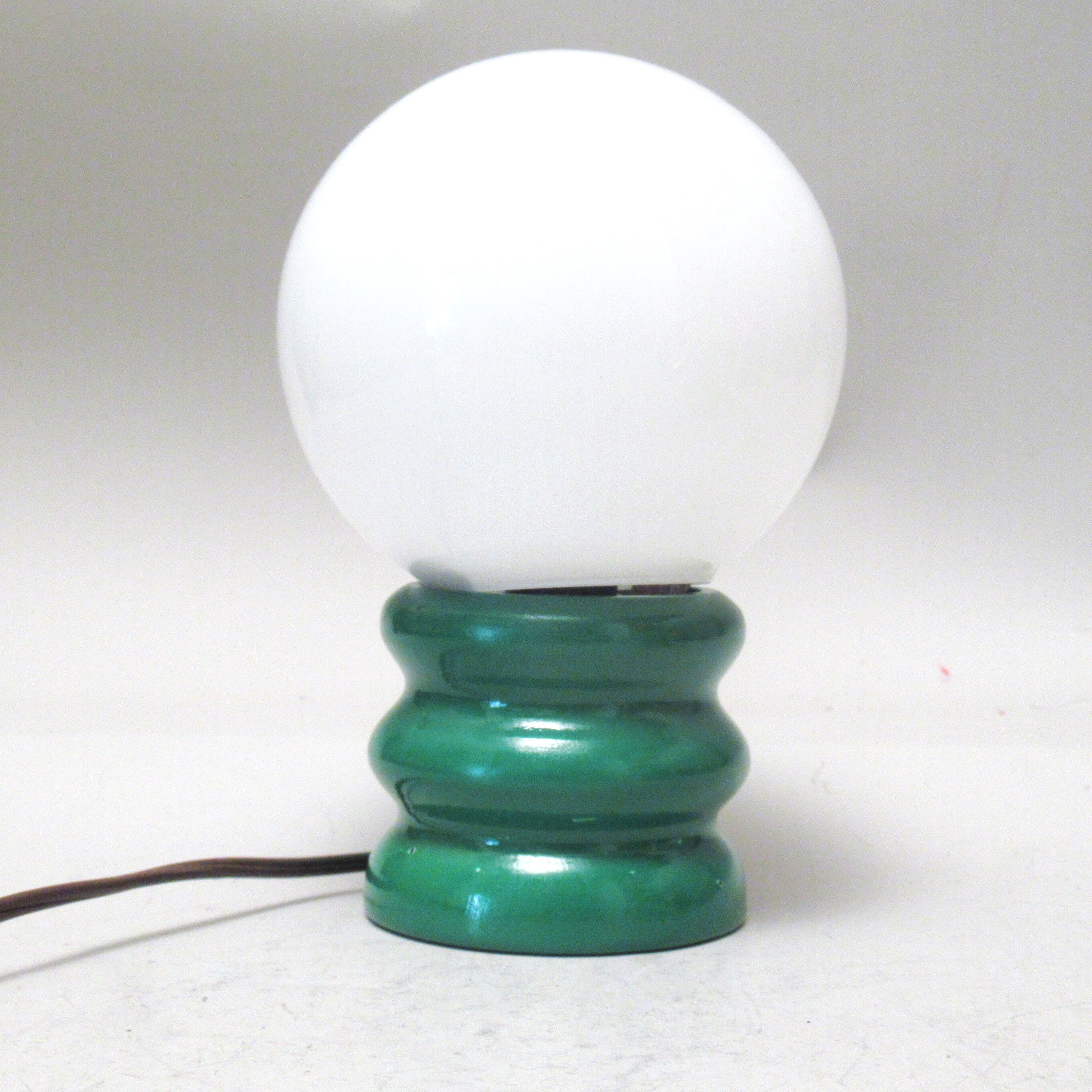 Green 1970s floor lamp with a globe shade.