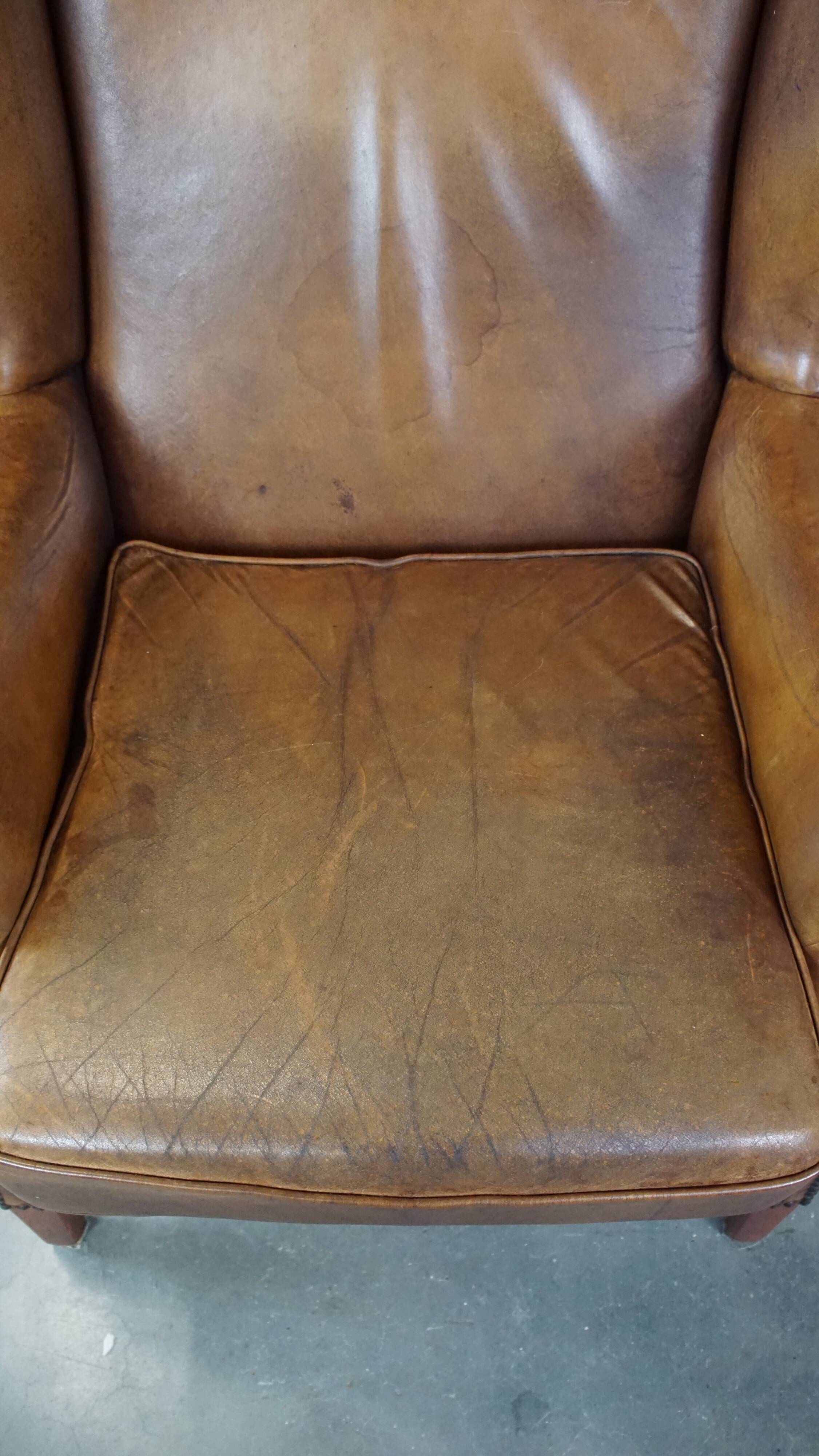 Charming sheep leather wingback armchair with a beautiful patina and excellent seating comfort