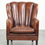 Comfortable sheepskin armchair in unique design finished with black piping