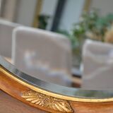 Old oval beveled wooden mirror, partly gilded and carved